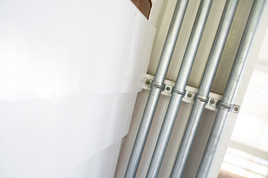 Metal Electrical Conduits and White Wall in Interior Space