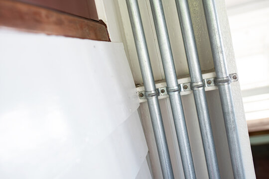 Metal Electrical Conduit Pipes Installed in Building Wall