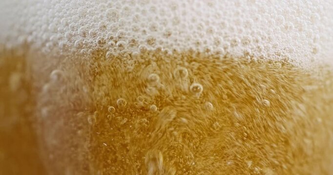 Macro View of Golden Beer Bubbles and Thick White Foam
