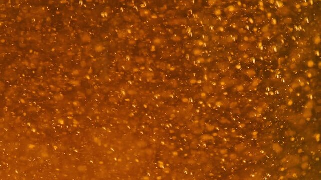Extreme Macro of Golden Beer Bubbles Rising with White Foam 
