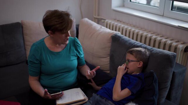 Mother Talking to Son on Sofa in Living Room, Providing Guidance and Support