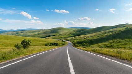 Obraz premium Curving road in a green landscape under a blue sky with few clouds in the mid-afternoon light