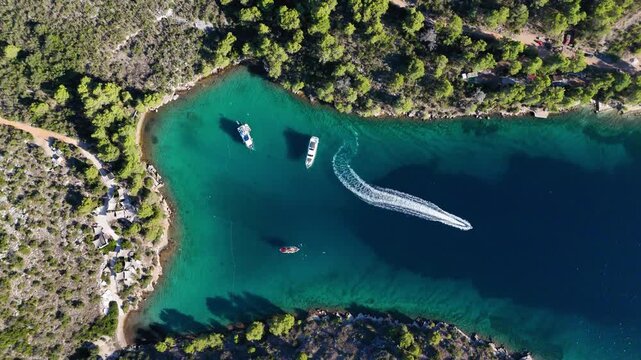 Speedboat cruising through beautiful zavala cove in hvar croatia