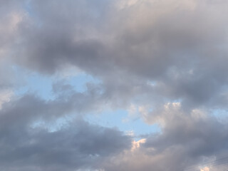 Obraz premium Dramatic Dark Clouds Opening to a Soft Blue Sky at Dusk for Atmospheric Nature Backgrounds