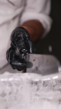 Barman cortando un bloque de hielo con cuchillo y martillo. Barman cortando un bloque de hielo con cuchillo y martillo.