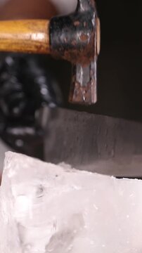 Barman cortando un bloque de hielo con cuchillo y martillo. Barman cortando un bloque de hielo con cuchillo y martillo.