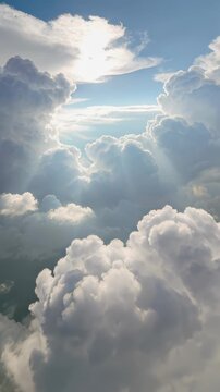 Sunbeams breaking through towering cumulus clouds in vertical orientation. Lockdown shot of dramatic sky.