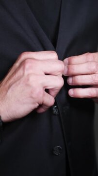 Barman aboton&aacute;ndose el chaleco negro, listo para servir. Barman profesional abroch&aacute;ndose el chaleco negro. Servicio de bar elegante, preparaci&oacute;n profesional para la hosteler&iacute;a.