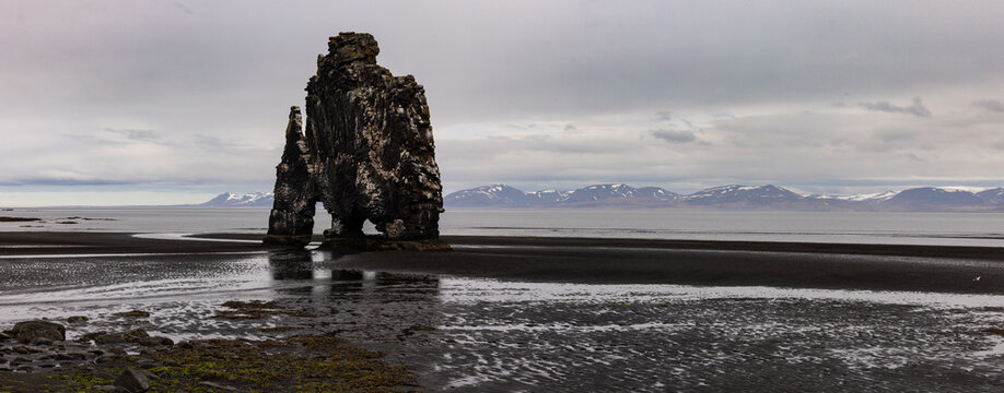 Arche rocheuse basaltique isol&eacute;e sur une plage de sable noir au paysage nordique en Islande. Hv&iacute;tserkur
