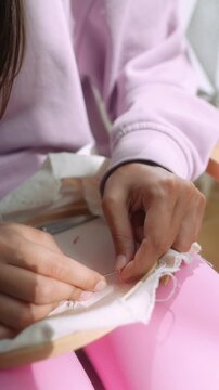 Caucasian hobbyist seamstress handstitching embroidery