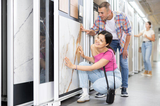 Young married couple chooses floor tiles for their home together