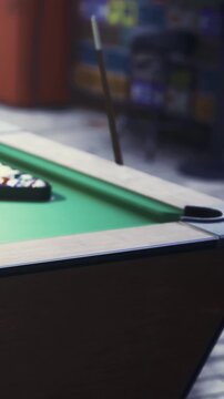 A pool table is set up with balls arranged in a triangle at a local gaming spot. Players are nearby, ready to start a game and enjoy their time.