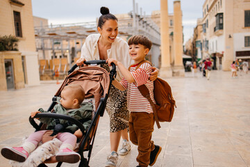 Naklejka premium Mother and two twin kids travelers