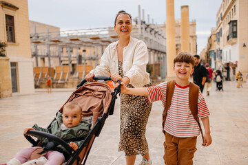 Naklejka premium Mother and two twin kids travelers