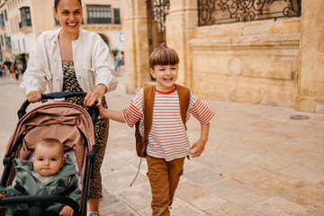 Naklejka premium Mother and two twin kids travelers