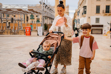 Naklejka premium Mother and two twin kids travelers