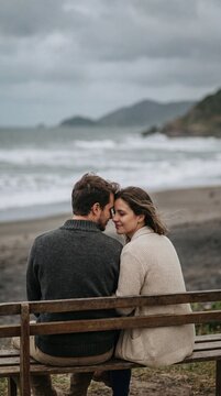 Romantic Couple Sitting Together on a Cold Beach Watching the Ocean &ndash; Cinematic Valentine&rsquo;s Day Coastal Lifestyle With Cozy Winter Clothing, Emotional Intimacy and Calm Romantic Atmosphere
