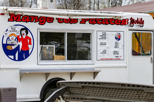 Parents, Quebec, 20 May 2026 : A white food truck with 'Mange tes Patates Mobile' branding and a menu board displays 'Closed' sign