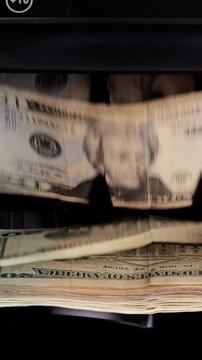 Money counting machine. Currency counting machine counting US money. Slow Motion, vertical video.
