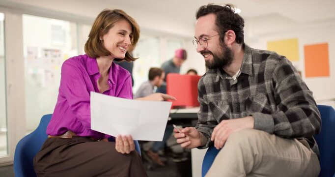 Business team discusses project details in office with focus on collaboration and planning during busy work hours