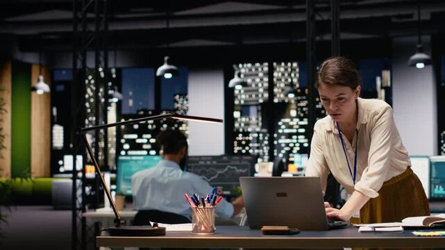 Woman employee in office completing spreadsheets on laptop, organizing agenda and creating action plan. Manager typing on keyboard, researching information and analyzing data online.