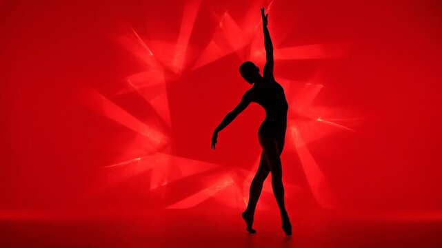 Ballerina silhouette dancing en pointe on vibrant red stage