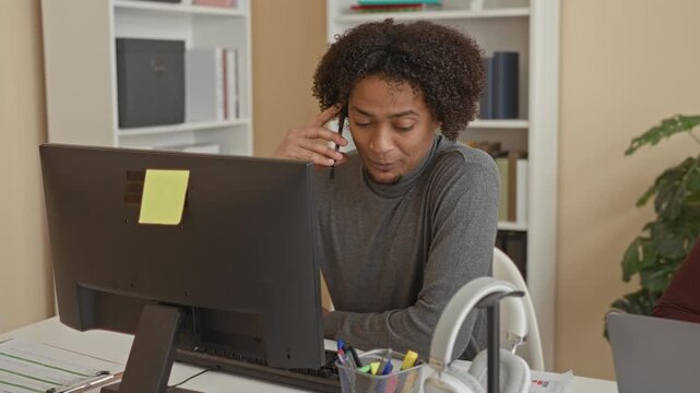 Man and woman clasp hands across a cluttered desk with laptop, desktop monitor, headphones and scattered pens while man holds a smartphone and woman looks on in office; teamwork trust.