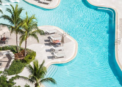 aerial drone woman pool relaxing chair miami florida
