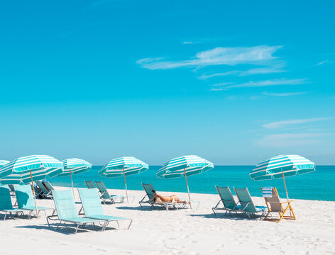 bikini woman on beach chair with colorful umbrellas in miami florida