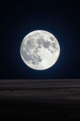 Obraz premium Full moon shines brightly over empty dark landscape. Lunar surface terrain is illuminated by moon glow. Night sky with large celestial body.