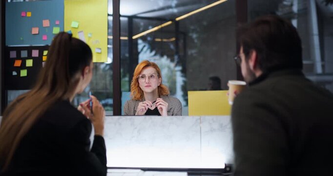 Discussion at a modern office with three people engaging over coffee in a workspace during a weekday morning