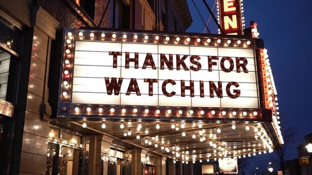 Thanks for watching text on glowing movie theater marquee sign at night.