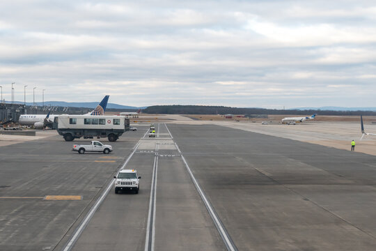 Dulles Airport, Virginia, USA - January 2, 2024 - Washington Dulles International Airport ramp operations showing Dulles Mobile Lounge, AeroTrain guide rail, United Airlines aircraft