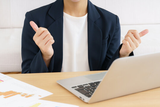 ノートパソコンでビデオ通話する若い日本人女性の身振り手振りの手元のアップ