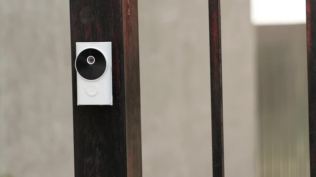 Modern intercom system on gate outdoors, closeup. Camera moving right