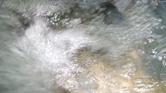 Silent clear mountain stream water rushing and foaming over rocks