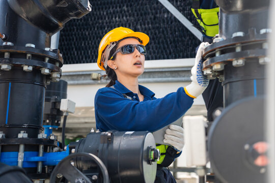 Female engineer with tablet inspecting industrial cooling system pipes, Technician performing technical maintenance on HVAC, Expert woman working on industrial plumbing and pipeline maintenance check