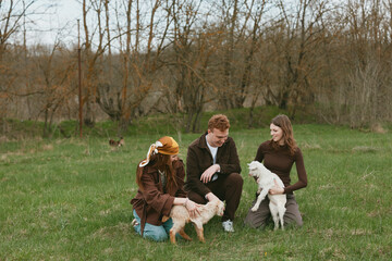 Fototapeta premium Goat kid lifestyle outdoor scene with friends in a park, featuring a friendly animal and pet companionship, as nature sunlight and smiles capture joyful interaction and warm togetherness.