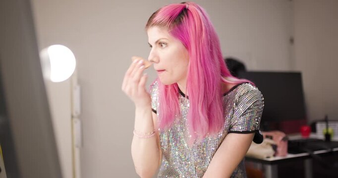 Girl with pink hair prepares for a modeling session in a stylish setting while showcasing her unique look and personality