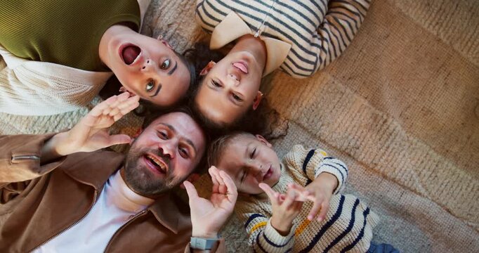 Parents, kids and above with funny face on floor, smile and bonding for love, laying or relax in home. Happy people, mom and dad in portrait, children and joke on carpet with laugh at family house