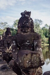 Fototapeta premium Ancient stone statues line the causeway to Angkor Wat temple complex in South Gate Angkor Thom, , Siem Reap, Cambodia. These figures guard the entrance to the sacred site.