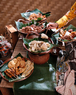 A variety of traditional snacks and foods typical of Yogyakarta - Indonesia arranged on clay and banana leaf containers, showcasing authentic culinary heritage and local flavors.