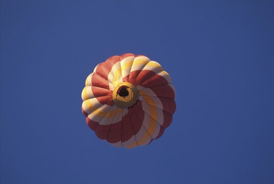 Red and yellow hot-air baloon in the blue sky