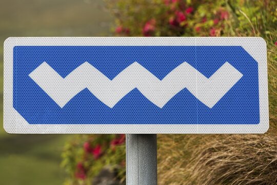Blue and white sign with wavy logo marks Irish coastal road Wild Atlantic Way, WAW, West Coast, Ireland