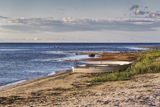 Rowing boat lies on natural beach, sandy beach in summer, evening sun, Ekeviken Bay, F&aring;r&ouml; Island, Far&ouml;, Gotland, Baltic Sea, Sweden