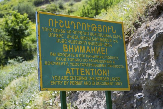 A multilingual warning sign regulating access to the border zone, sign in front of a military post on the border with Azerbaijan, near Goris, Armenia