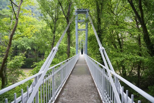 Abandoned suspension bridge passing through dense green forests, in a quiet and natural environment, Pineios River, Tempe Valley, Tembi Valley, Thessaly, Greece