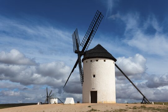 White windmill under a dramatic sky with other mills in the background, Campo de Criptana, Ciudad Real province, Castilla-La Mancha, Don Quixote Route, Spain