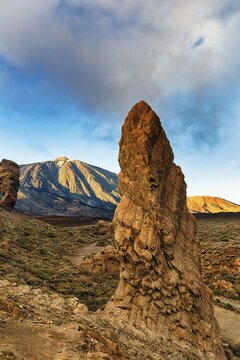 Bizarrely shaped tower of volcanic rock in front of Teide Volcano, Los Roques de Garcia, evening light, Teide National Park, Tenerife, Spain
