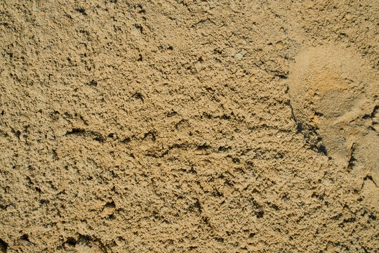 Daytime outdoor shot of industrial bulk building aggregate sand with high granularity and localized physical soil disturbances